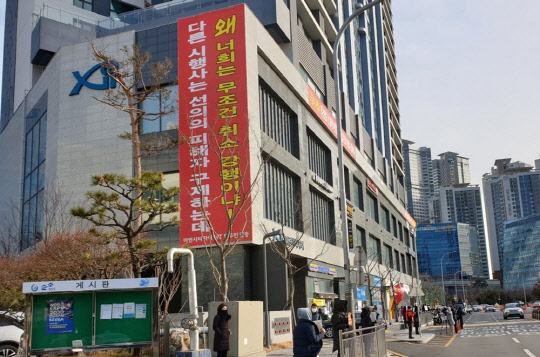 부정 청약 사태 여파로 시행사가 공급계약 취소 위기에 몰린 부산 해운대구 마린시티 아파트 일부 입주민들이 지난 7일 부산 해운대구 마린시티자이 아파트 앞에서 피켓 시위를 하고 있다. <연합뉴스>